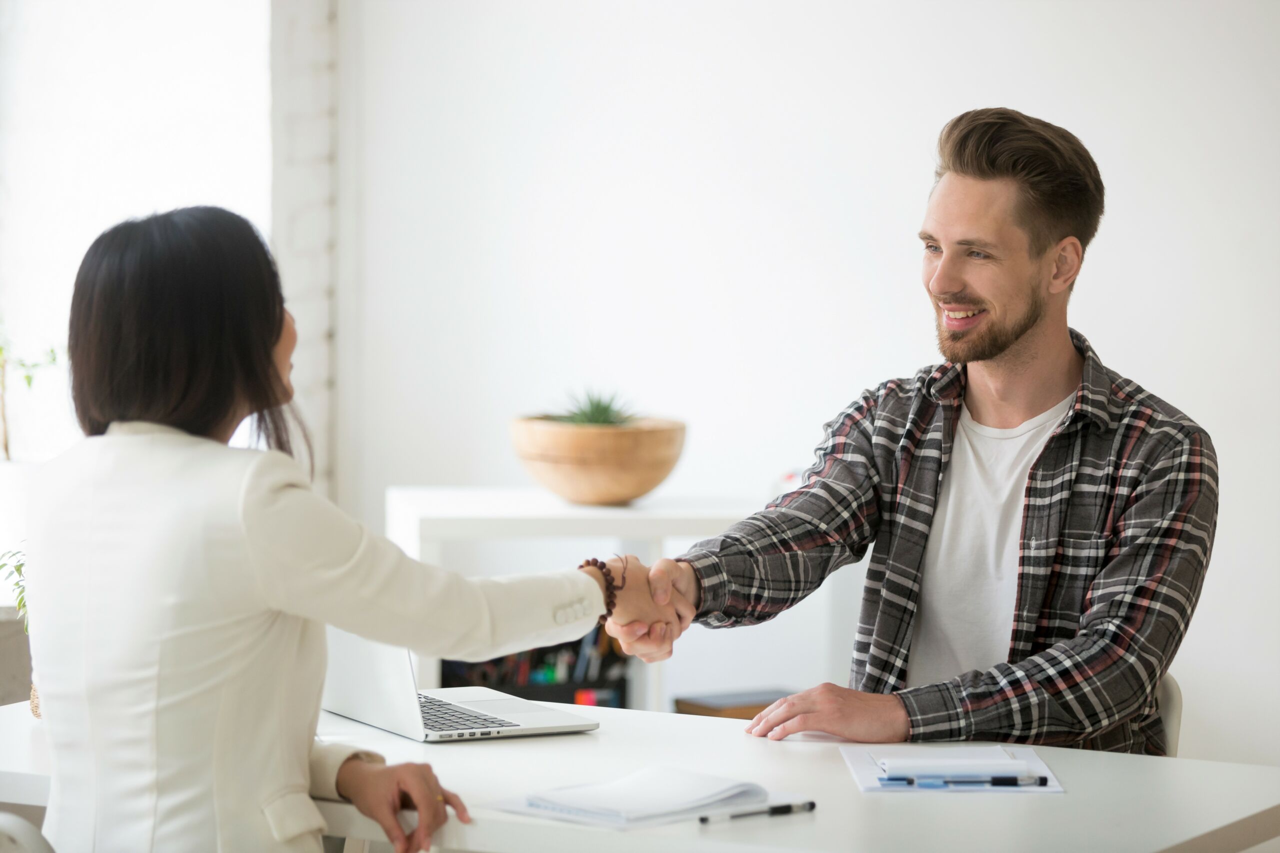 Interviewpartner schütteln einander lächelnd die Hände